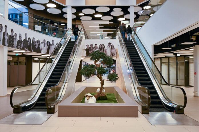 Rolltreppen in modernem Einkaufszentrum mit Personen.