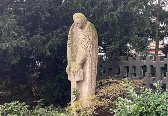 Steinskulptur eines Engels in einem Garten.