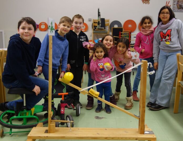 Kinder spielen im Klassenzimmer mit Kugelbahn.