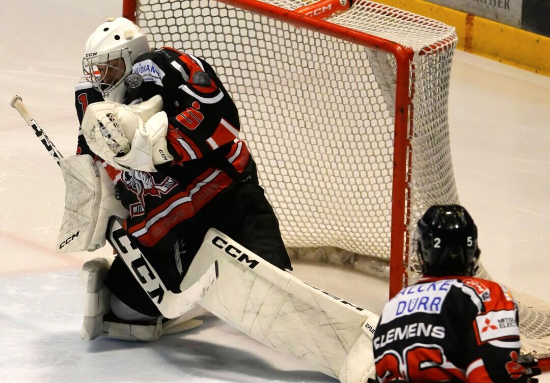 Eishockeytorwart pariert Schuss auf das Tor.