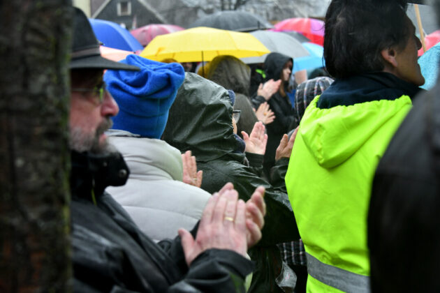 Menschen mit Regenschirmen bei einer Veranstaltung im Freien.