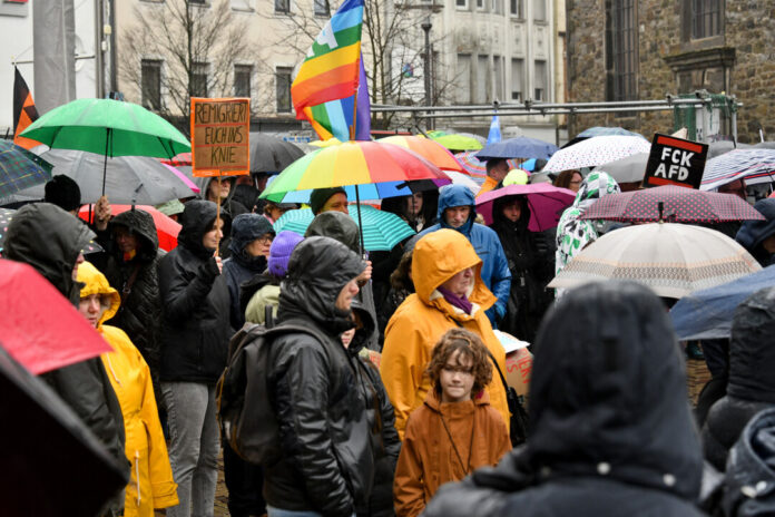 Demonstration mit Regenschirmen auf Straße.