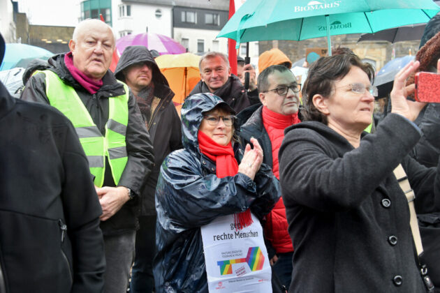 Menschen mit Regenschirmen bei einer öffentlichen Versammlung.