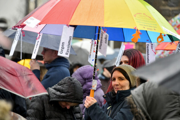 Demonstration mit bunten Regenschirmen gegen Rassismus.