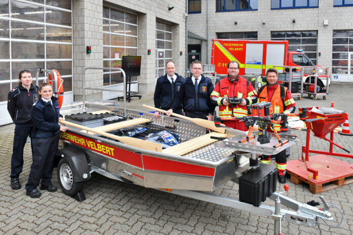 Feuerwehrleute mit Ausrüstung vor Feuerwache.