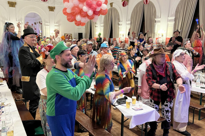Karnevalsfeier mit kostümierten Teilnehmern in einem Saal.