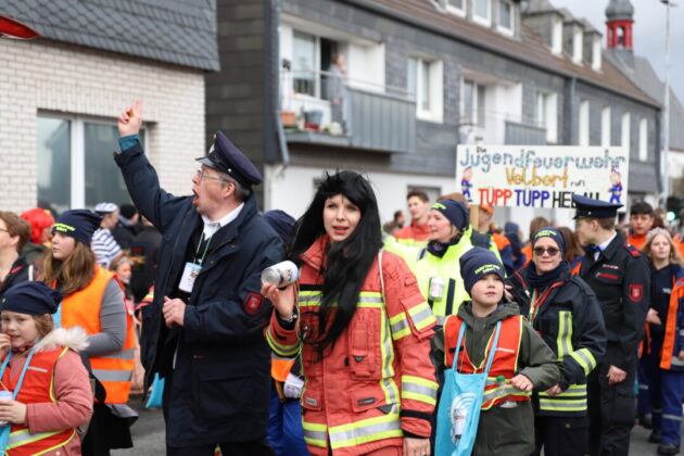 Karnevalsumzug mit Feuerwehrleuten und Kindern in Deutschland.