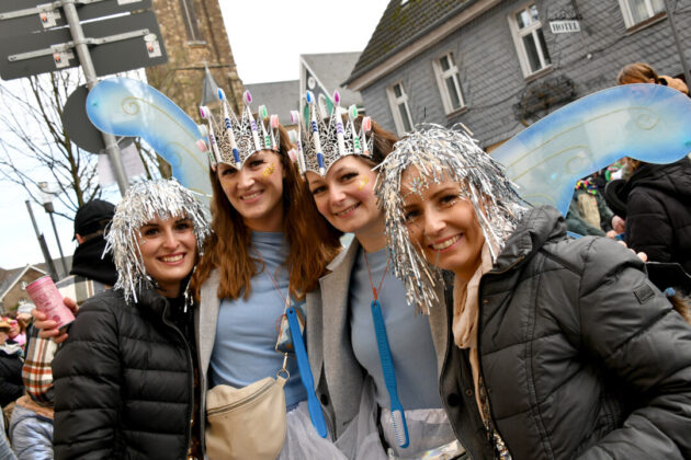 Frauen feiern Karneval mit Engelsflügeln und Kronen.