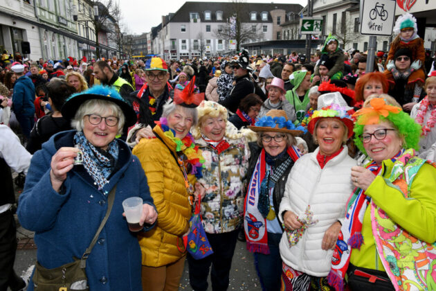 Fröhliche Menschen beim Karnevalsumzug in Kostümen.