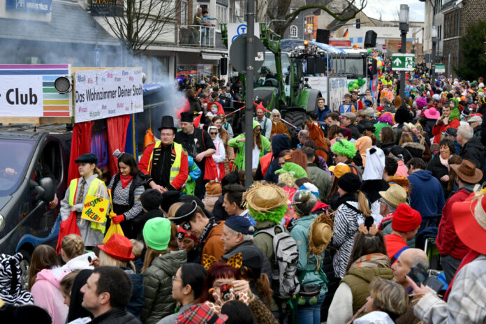 Karnevalsumzug mit kostümierten Menschen und Festwagen.