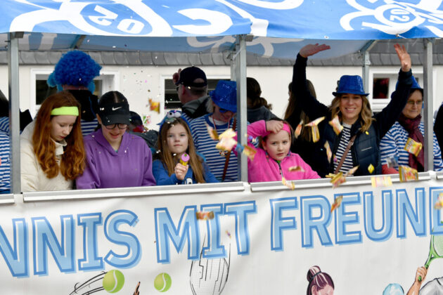 Karnevalswagen mit fröhlichen Kindern und Konfetti.