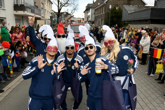 Karnevalsumzug mit feiernden Menschen in Kostümen.