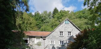 Bergische Diakonie: Sommerkurse im Atelier Verstecktes Haus umgeben von Bäumen und Sträuchern.