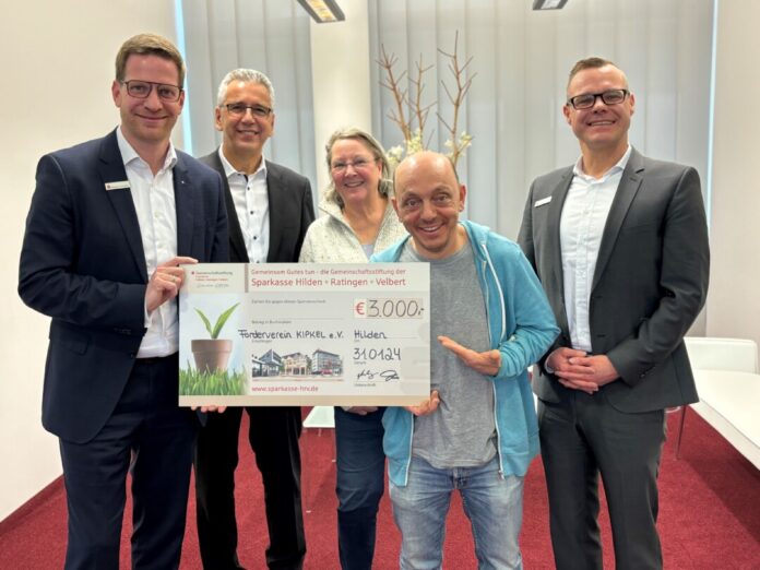 Gruppe hält Scheck der Sparkasse.