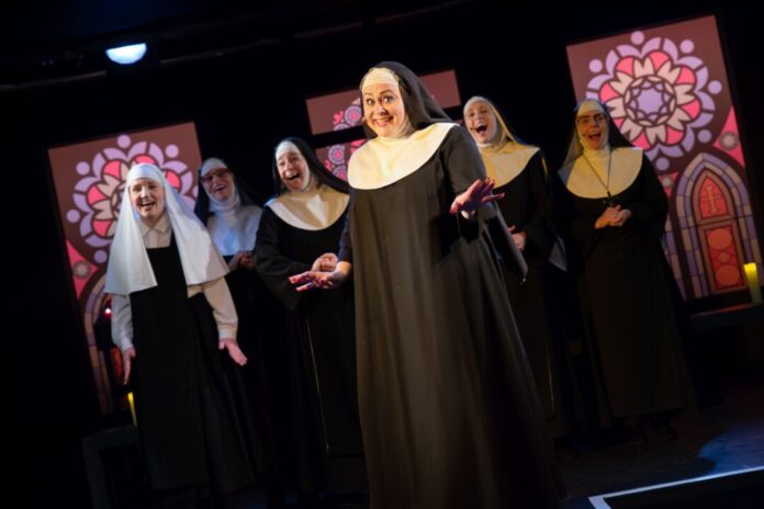 Nonnen performen auf Theaterbühne.
