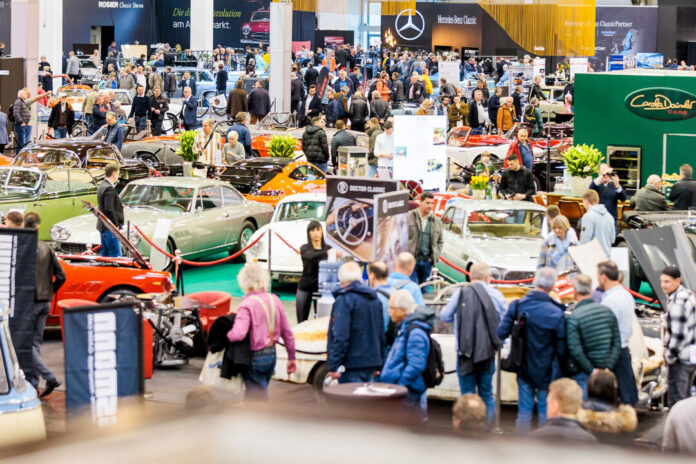 Oldtimer-Messe mit vielen Besuchern und klassischen Autos.