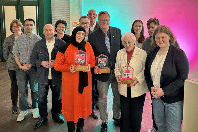 Gruppe mit Auszeichnungen bei Veranstaltung.