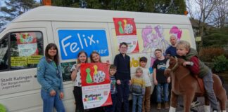 Eggerscheidter Kinder zeigen das Plakat der Ratinger Spieletage und freuen sich auf Felix' ersten Einsatz am Wochenende. Foto: Stadt Ratingen