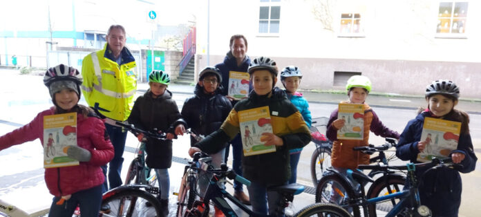 Konrektor Benjamin Lonnemann, Uwe Zimmermann, Geschäftsführer Kreisverkehrswacht Mettmann, und Schüler der Katholischen Grundschule Mettmann. Foto: Kreisverkehrswacht