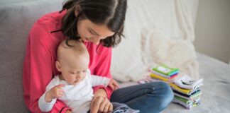Mutter liest Buch mit Baby.