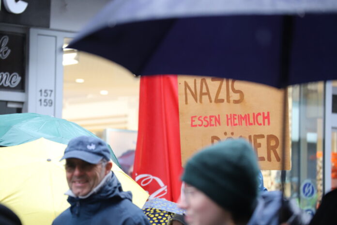 Demonstration mit Plakat und Regenschirmen