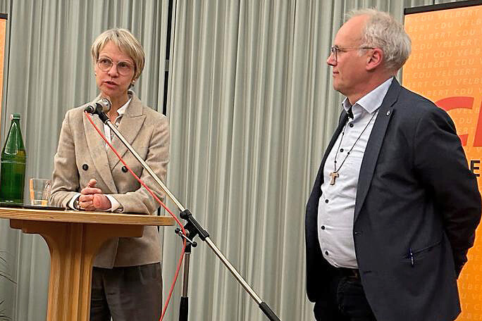 Frau und Mann bei Podiumsdiskussion.