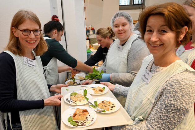 Freiwillige servieren Essen bei Wohltätigkeitsveranstaltung.