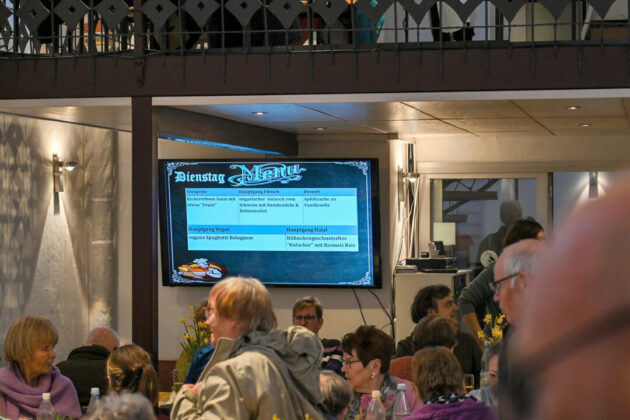 Speisekarte auf Bildschirm in Restaurant mit Gästen