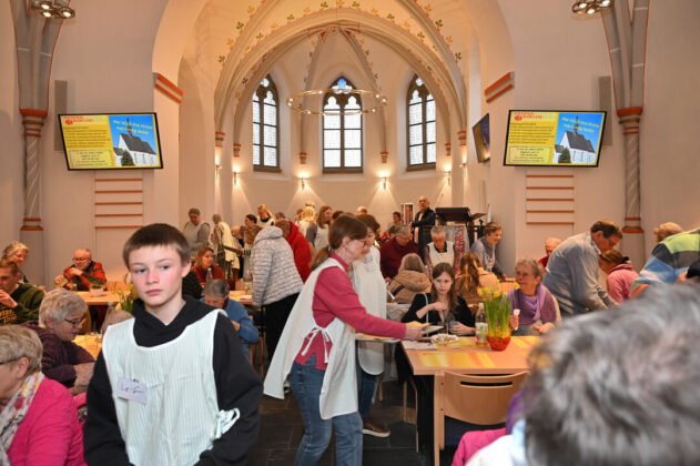 Menschen bei Veranstaltung in renovierter Kirchenarchitektur.