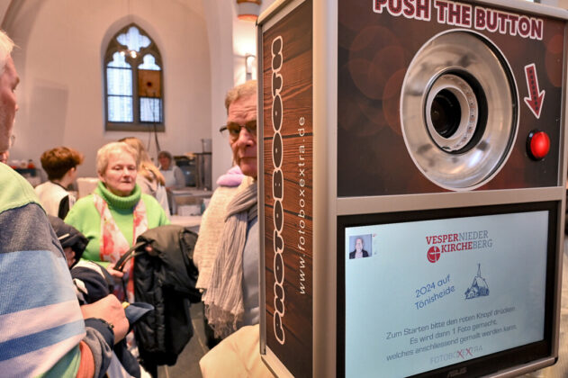 Menschen betrachten Fotobox in einer Kirche.