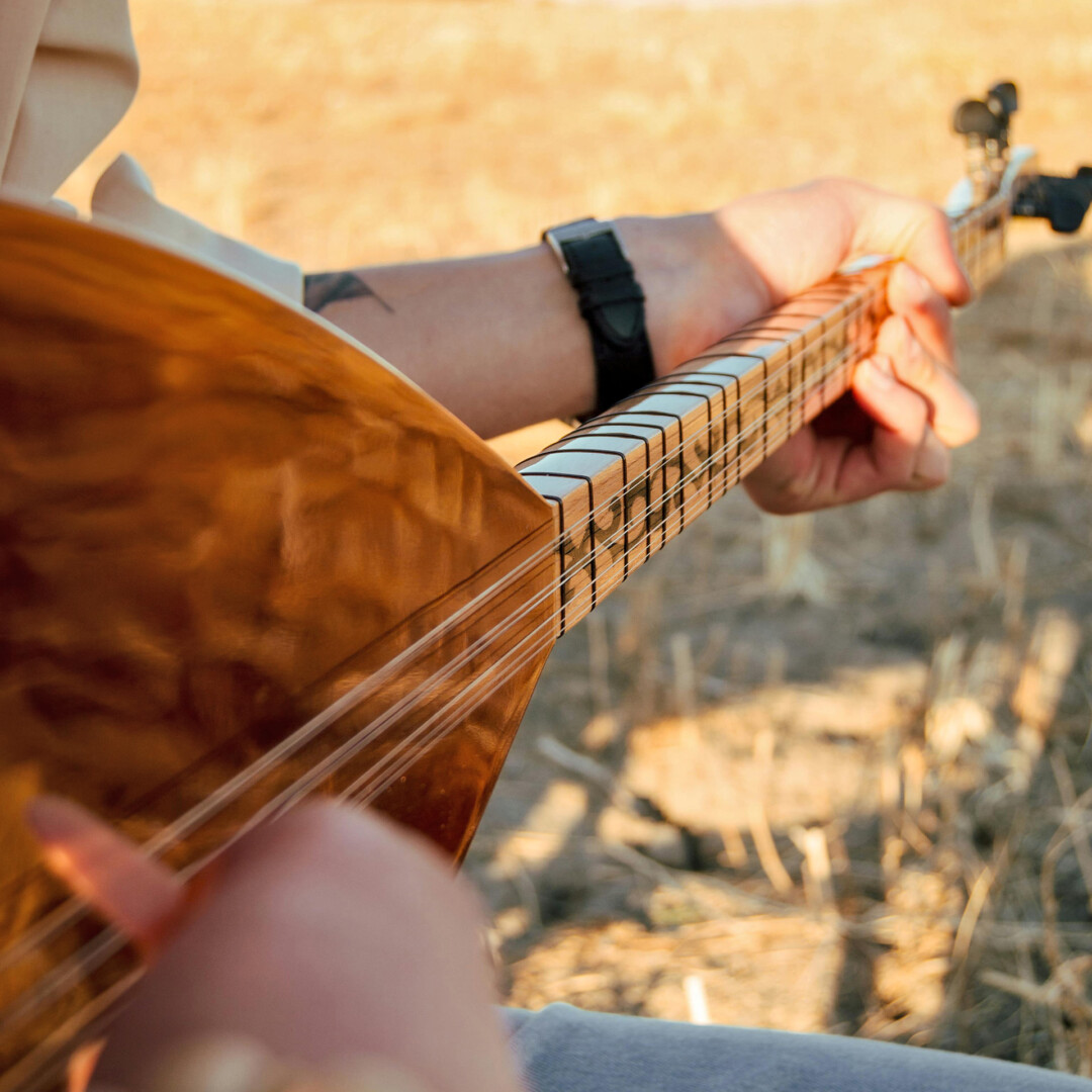 Person spielt Akustikgitarre im Freien
