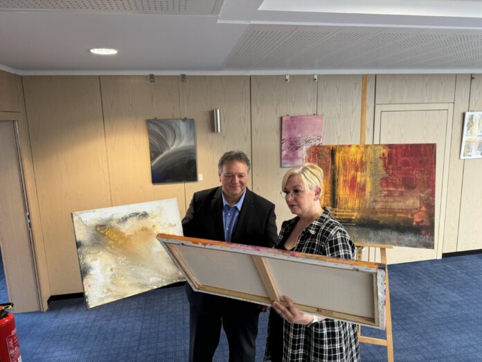 Christina Gratzel und Gebietsdirektor Thomas Döring betrachten eines der Werke. Foto: Kreissparkasse