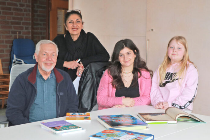 Gemeinsam zum Erfolg: Jochen, Handan, Hindrin und Fiona zusammen an einem Tisch. Foto: Caritas