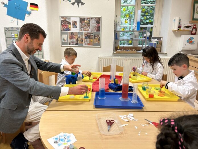 Der Essener Landtagsabgeordnete Fabian Schrumpf am Tisch mit einigen der Kinder. Foto: Anna Krapohl