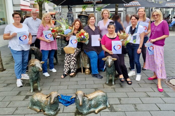 Bürgermeisterin Sandra Pietschmann und Beate Bosselmann vom Stadtmarketing (2. v. r.) nahmen die Siegerehrung an der Schäfchengruppe in der Fußgängerzone vor. Foto: Kreisstadt Mettmann
