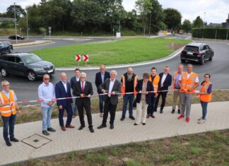 Landrat Thomas Hendele, Bürgermeister Klaus Pesch und die Technische Beigeordnete Petra Cremer durchschneiden das Band zur symbolischen Freigabe des neuen Kreisverkehrs Kahlenbergsweg. Foto: Stadt Ratingen