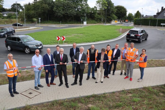 Landrat Thomas Hendele, Bürgermeister Klaus Pesch und die Technische Beigeordnete Petra Cremer durchschneiden das Band zur symbolischen Freigabe des neuen Kreisverkehrs Kahlenbergsweg. Foto: Stadt Ratingen