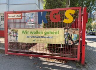 Am Eingangstor der Katholischen Grundschule hängt ein großes Banner: "Wir wollen gehen! Zu Fuß statt Elterntaxi". Foto: Kreisstadt Mettmann