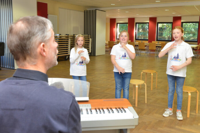 Chorleiter Matthias Röttger mit Kinder während einer Chorübung. Foto: Sebastian Sehr