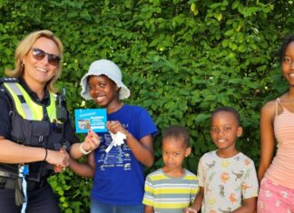 Tyra Kariuki und ihre drei Geschwister freuen sich über einen Gutschein für das Heljenbad in Heiligenhaus, den Polizeihauptkommissarin Katja Lindemann von der Präventionsdienststelle der Direktion Verkehr überreichte. Foto: Polizei
