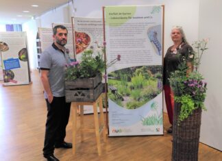 Angelika Genieser (Abteilung Natur-, Klima- und Umweltschutz) und Ahmet Özdemir (Leiter Stadtbibliothek) freuen sich über die neuen Pflanzgefäße, die jetzt die Ausstellung im Lesecafé des Medienzentrums schmücken. Foto: Stadt Ratingen