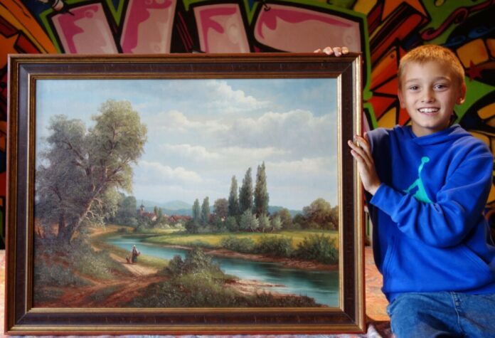Der achtjährige Liam aus Eggerscheidt zeigt das Bild, das man bei dem aktuellen Ratespaß des Ratinger Jugendamtes gewinnen kann. Foto: Stadt Ratingen