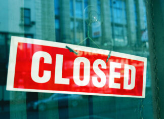 Ein Schild mit der Aufschrift "Closed" hängt an einer Tür. Foto: VZ NRW/adpic