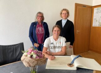 Leonie Menzel trägt sich ins Goldene Buch der Stadt ein. Bürgermeisterin Sandra Pietschmann hatte die Bronzemedaillengewinnerin von Paris ins Rathaus eingeladen, um ihr zu dem großartigen Erfolg zu gratulieren. Mit dabei war Uta Blome-Bastigkeit, die ehemalige Einrad-Trainerin der Mettmanner Sportlerin. Foto: Kreisstadt Mettmann