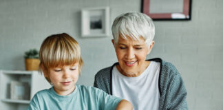 Eine Seniorin spielt mit einem Kind. Foto: istockphoto-1498121781/DRK Kreis Mettmann