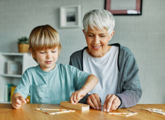 Eine Seniorin spielt mit einem Kind. Foto: istockphoto-1498121781/DRK Kreis Mettmann