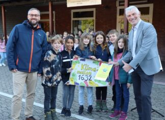 Bürgermeister Klaus Pesch (rechts) und Klimaschutzmanager Benjamin Reichpietsch überreichten den Schülerinnen und Schülern der Johann-Peter-Melchior-Schule die Urkunde für das Projekt Kindermeilen. Foto: Stadt Ratingen