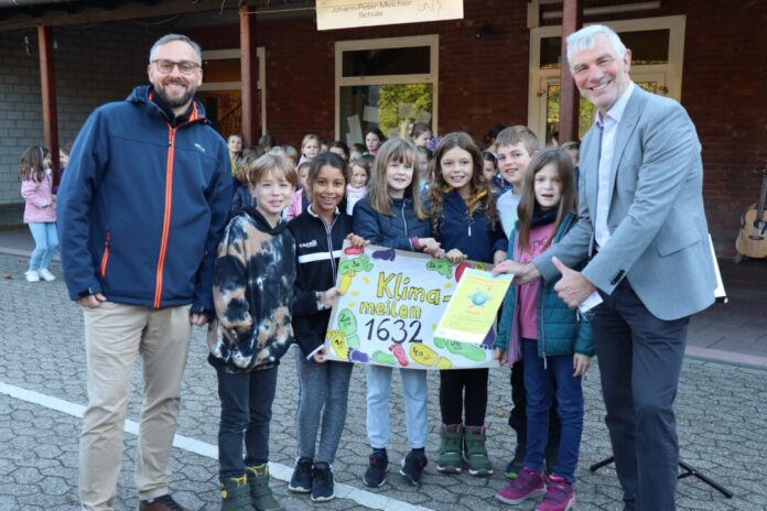 Bürgermeister Klaus Pesch (rechts) und Klimaschutzmanager Benjamin Reichpietsch überreichten den Schülerinnen und Schülern der Johann-Peter-Melchior-Schule die Urkunde für das Projekt Kindermeilen. Foto: Stadt Ratingen