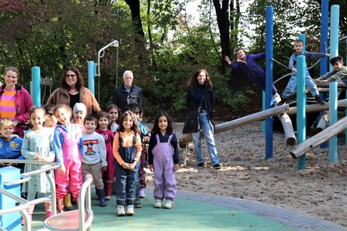 Die stellvertretende Bürgermeisterin Barbara Esser (stehend hinter den Kindern) eröffnete den seit Juni fertigen inklusiven Spielplatz im Erholungspark Volkardey nun endlich auch offiziell (rechts stehend die Planerin des Spielplatzes, Diana Schubert vom Amt für kommunale Dienste).  Foto: Stadt Ratingen