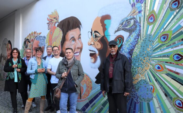 Zur Enthüllung des neuen Mosaik-Werks trafen sich (von links) die Immobilien-Eigentümer Manuela und Achim Egenberger, Mosaik-Künstlerin Sarah Rose, Gerold Fahr (Vorsitzender des Quartiersbeirates Ratingen Mitte), Graffiti-Künstler Julius Egenberger, Malerin Anja Schultz sowie Leonard Jones, einer der „Generationen-Köpfe“. Foto: Stadt Ratingen